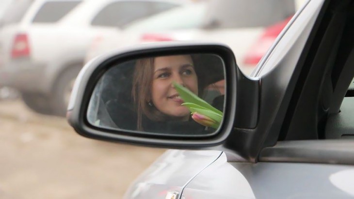 Expresión de una mujer vista desde el retrovisor de un coche 