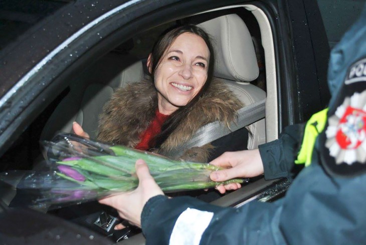 mujer feliz recibiendo flores por parte de la policía de Lituania 