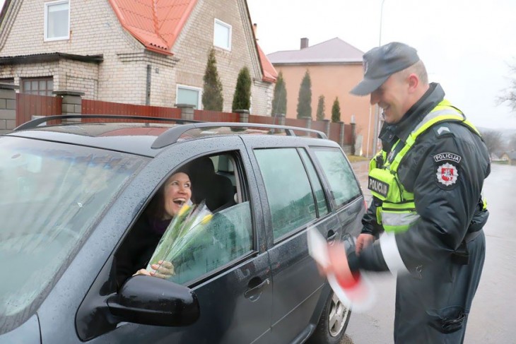 mujer en Lituania recibiendo flores por parte de la policía 