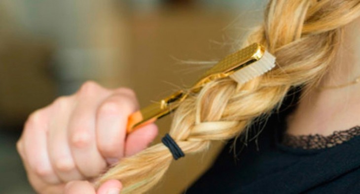 mujer peinando su trenza con un cepillo dental 