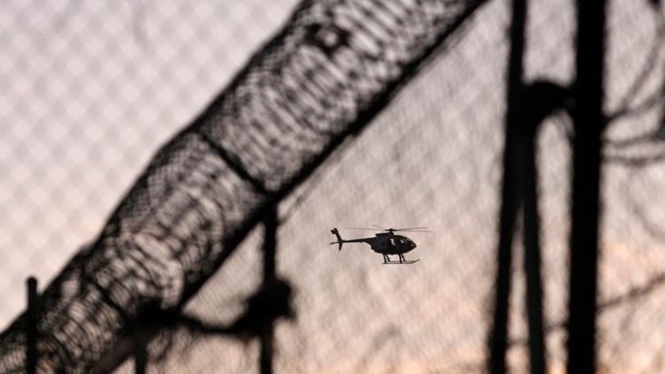 Helicóptero volando sobre el techo de una prisión 