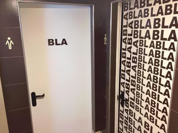 letreros baños: hombres, bla; mujeres, bla bla bla bla bla bla