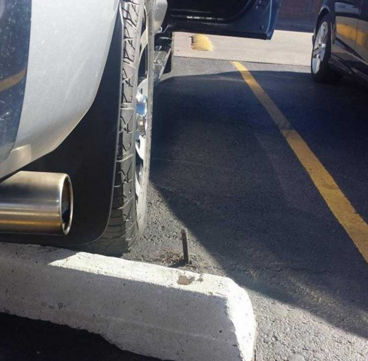 Un tornillo en el cemento del cajón para estacionarse