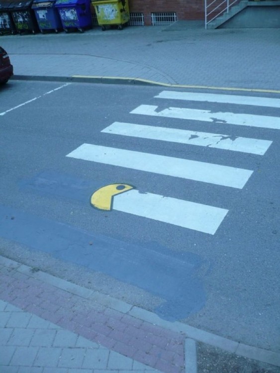 dibujo de pacman simulando que se come un señalamiento en el pavimento de una calle 