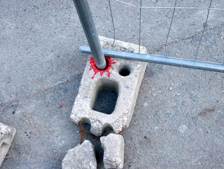 tubo perforando un ladrillo con un poco de pintura roja 