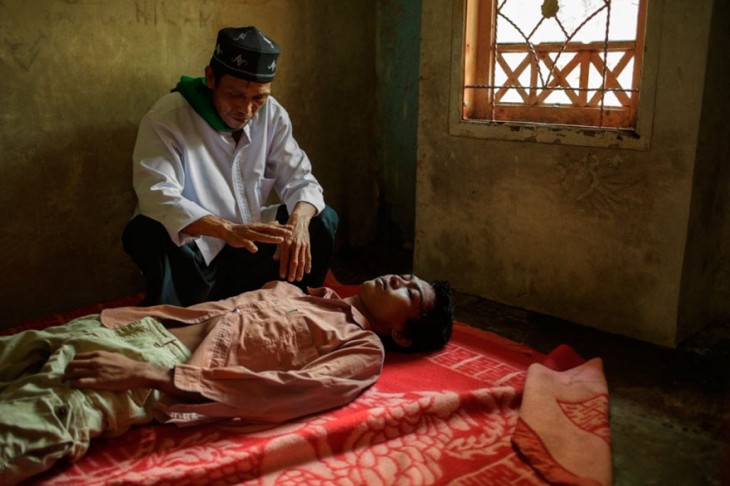 persona haciendo curación a un paciente de un hospital mental en Indonesia