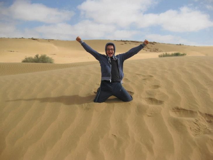 chico incado sobre el desierto de el Sahara 