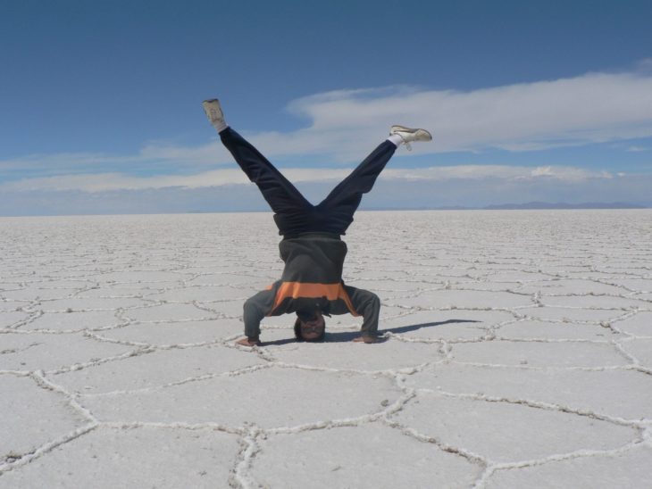 chico parado de cabeza sobre el salar en Bolivia 