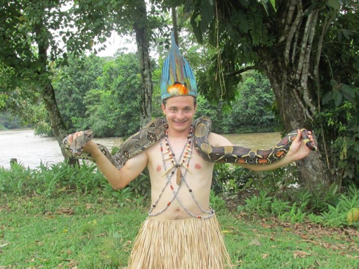 chico con una enorme serpiente en la selva del amazonas 