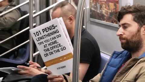 gif del video del chico que trolleó a los pasajeros de un metro de Nueva York leyendo libros falsos.