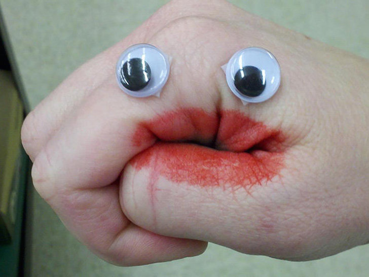 mano de una persona con ojos de plástico 