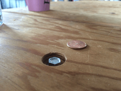 gif que muestra como encaja perfecto una moneda en un hueco de una mesa de madera 