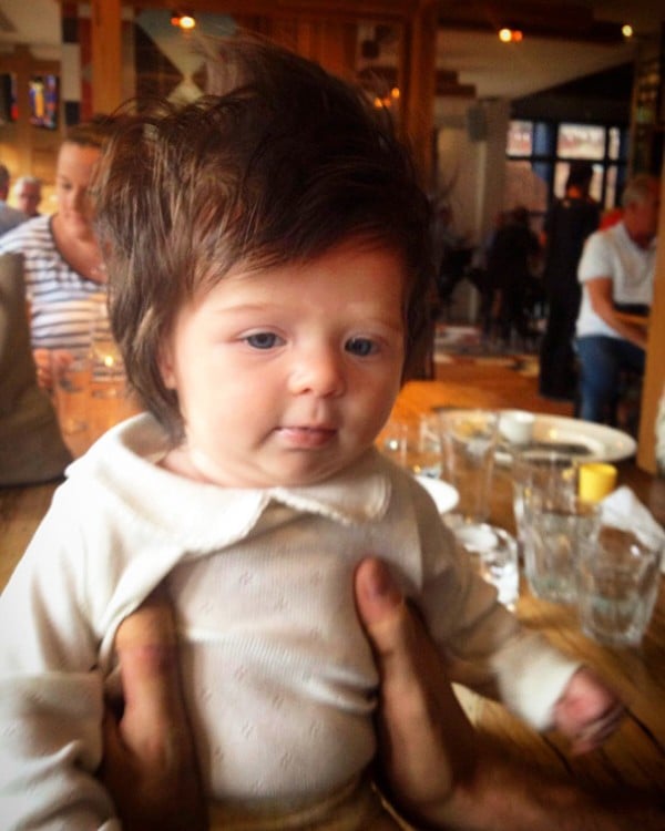 foto de una niña con mucho cabello sentada sobre la mesa de un bar 