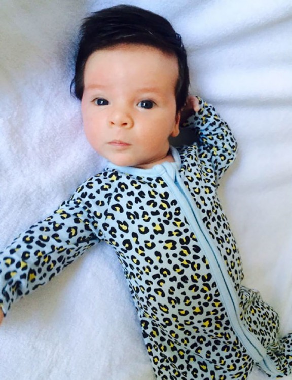 imagen de un bebé acostado con un mameluco en color azul 