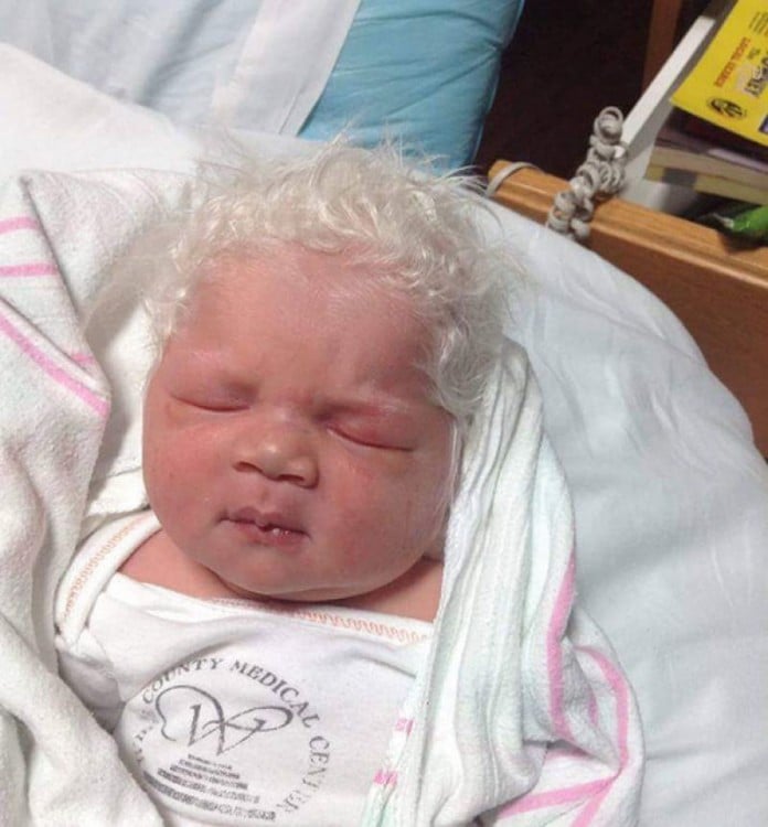 foto de un bebé recién nacido con mucho cabello de color blanco 