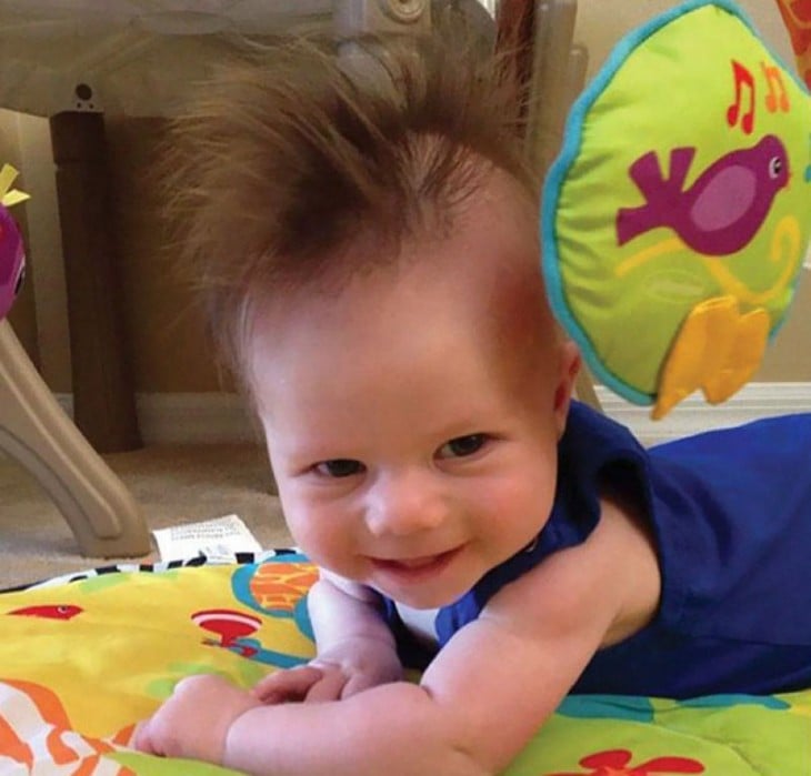 foto de un niño boca abajo con una moja de un cabello muy largo 