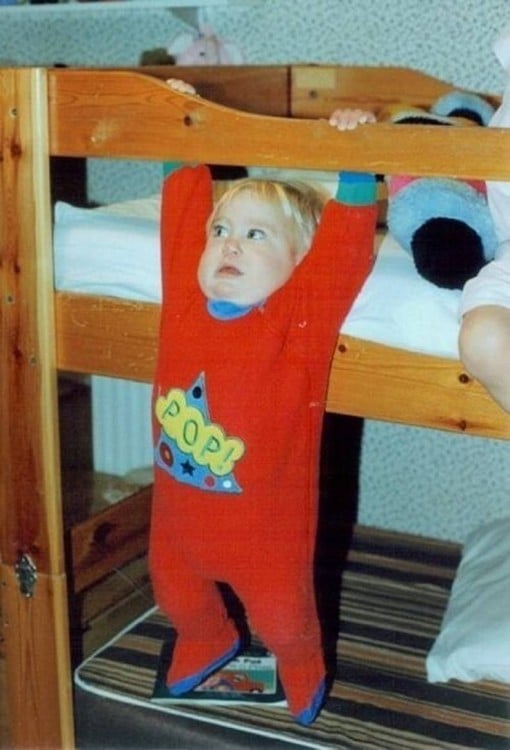 foto de un niño a punto de caerse de una cama 