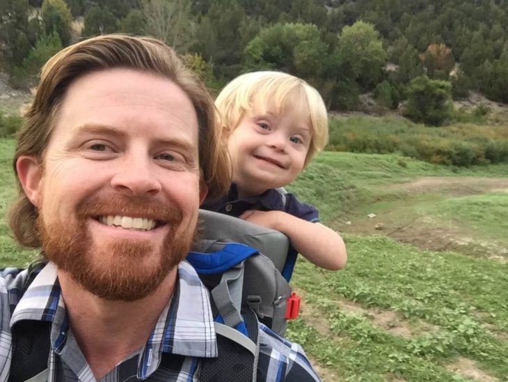 William, niño con Síndrome de Down, sonriendo junto con su papá Alan Lawrence