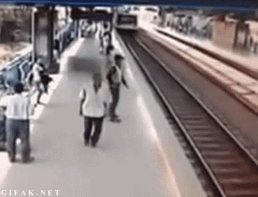 hombre va en la estación del metro y se tropieza justo cuando viene el tren pero el guardia alcanza a jalarlo y rescatarlo