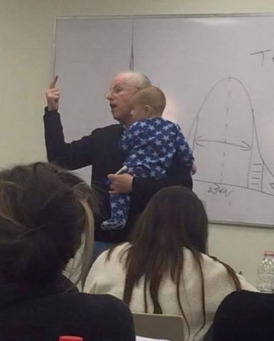 profesor dando clases con el hijo de su alumna en brazos