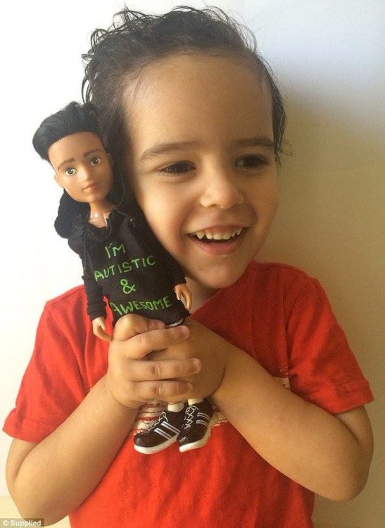 Niño con autismo con un muñeco que trae una playera que dice que tiene autismo #ToyLikeMe