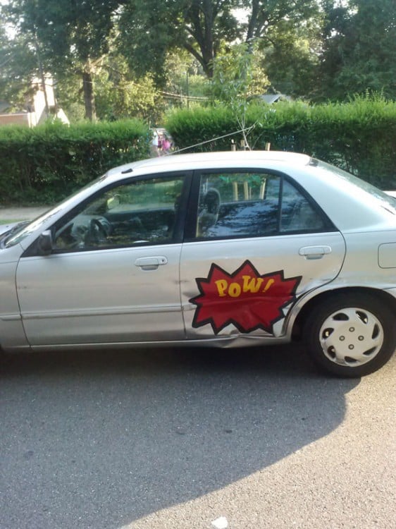 puerta de coche chocada con imagen de golpe de superhèroes