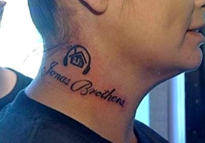 mujer con un tatuaje de los jonas brothers en su cuello