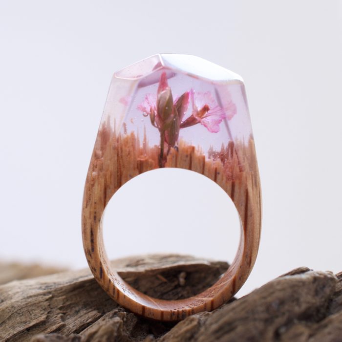 anillo de madera con una flor rosa dentro 