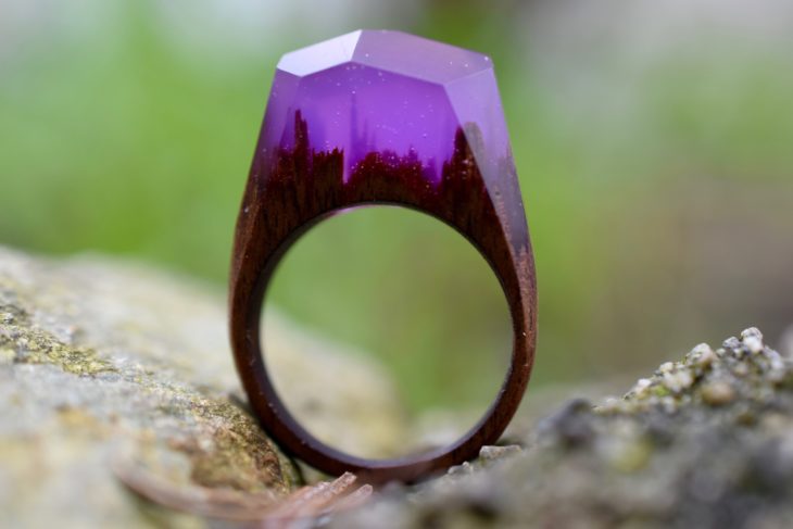 anillo de madera con un paisaje encapsulado con un material de cristal en color morado 