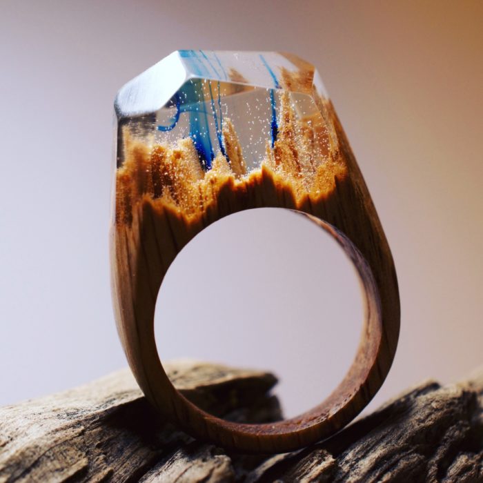 anillo de madera con un paisaje de árboles con un poco de tinta azul 