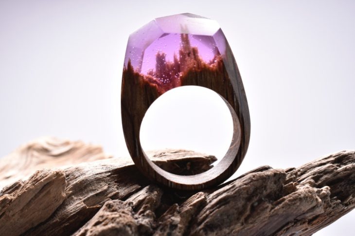 Anillo de madera con un paisaje dentro con una resina rosada 