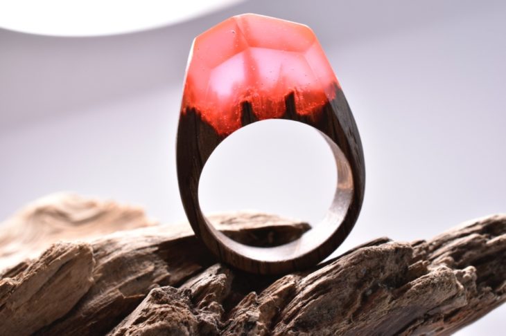 anillo de madera encapsulado en resina en color rojo con un minipaisaje dentro 