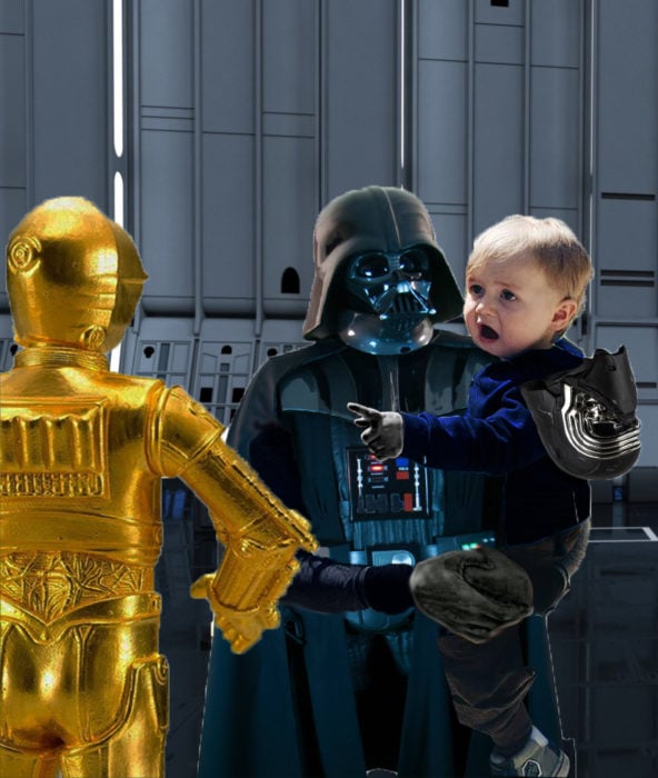 bebé sorprendido en brazos de Darth Vader señalando a un robot 