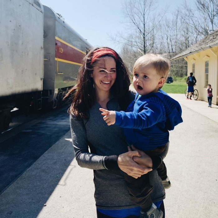 fotografía de una mujer cargando a su bebé sorprendido por ver un tren por primera vez 