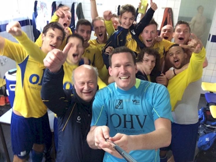 equipo de futbol tomandose una foto con el fondo un amigo que también sale pero bañandose