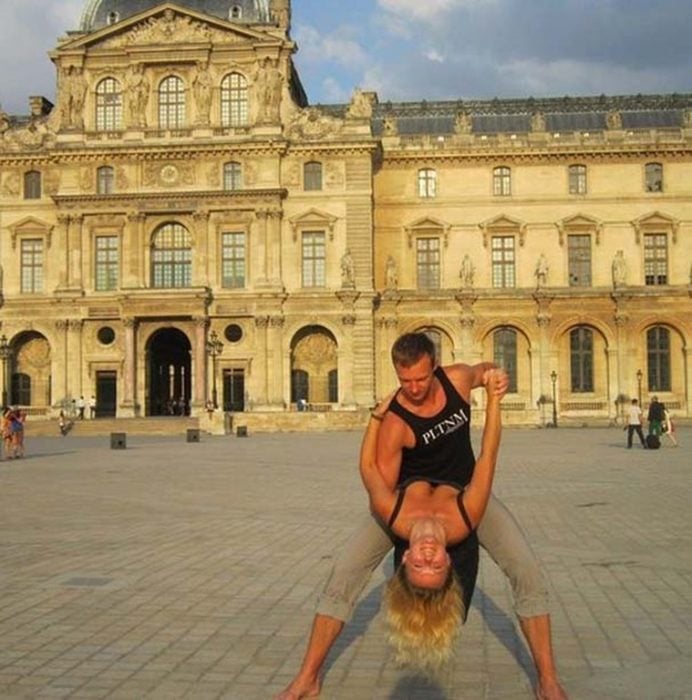 fotografía de una pareja bailando frente a un edificio histórico 