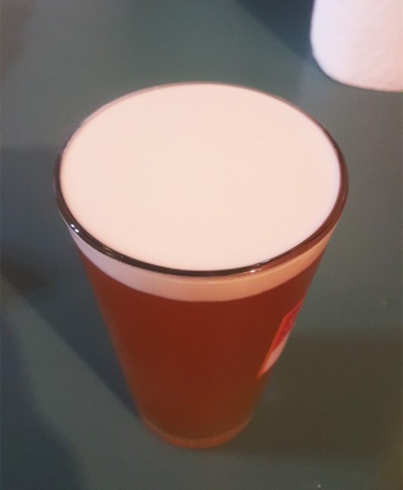 vaso de cerveza con espuma en su parte superior 