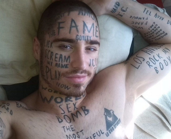 hombre todo tatuado con frases en su rostro