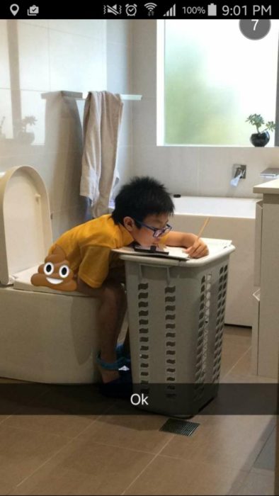 NIÑO EN LA TAZA DEL BAÑO MIENTRAS HACE LA TAREA