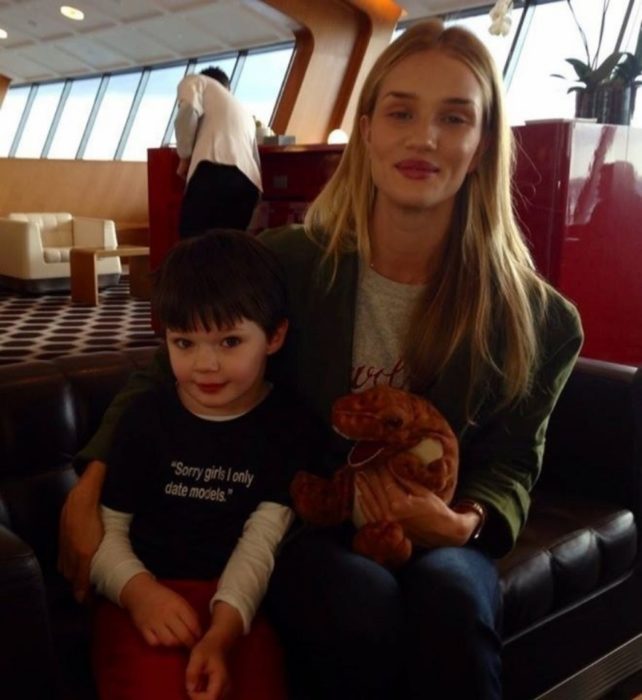 modelo Rosie Huntington-Whitley a lado de un niño con una camiseta que dice "Lo siento chicas, sólo salgo con modelos"