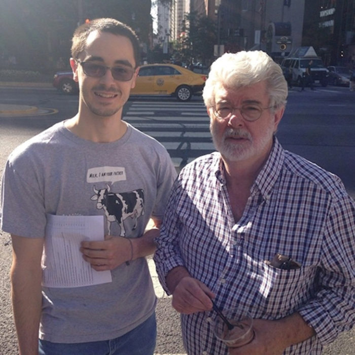 George Lucas Creador de las salgas fílmicas de Star Wars a lado de un chico con una playera de una vaca que dice "Leche, yo soy tu padre" 