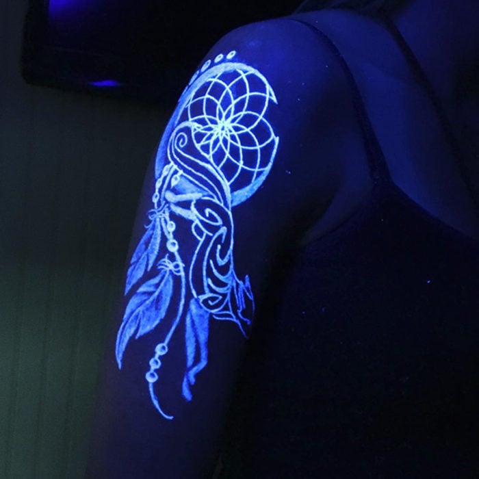 tatuaje ultravioleta con el diseño de un atrapasueños