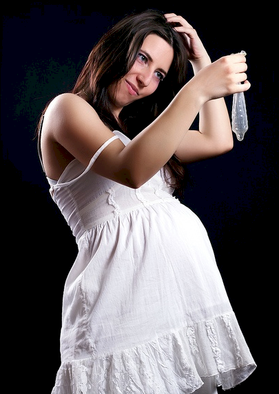 Mujer embarazada con preservativo en mano