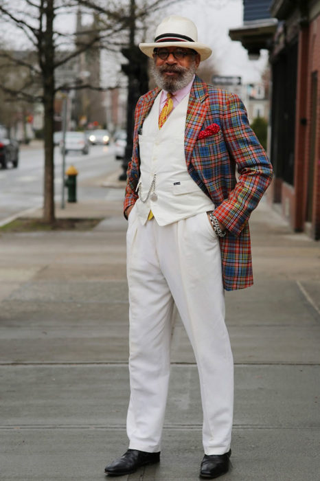 Hombre de +60 años vestido muy elegante con traje blanco y abrigo de colores
