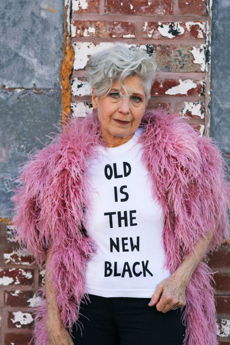 Mujer de +60 años usando una playera que dice VIEJO ES EL NUEVO NEGRO