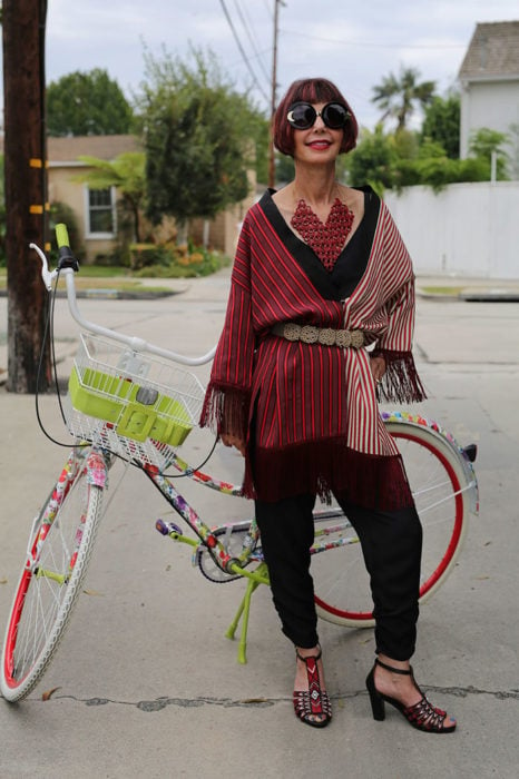 Mujer de +60 años con ropa negra y roja en una bici