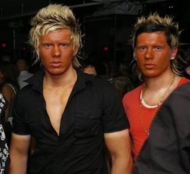 Antro. Foto de dos chicos con el cabello teñido y la cara naranja de bronceado pero el pecho pálido