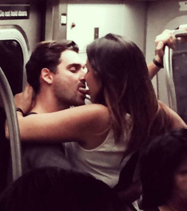 Hombre y mujer besándose con la lengua en el metro