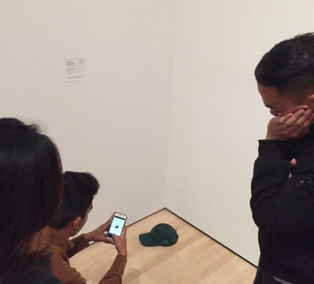 Personas toman fotografías de una cachucha en un museo