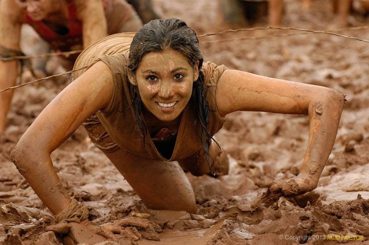 Una mujer en una competencia está llena de lodo pero sale guapa en la foto